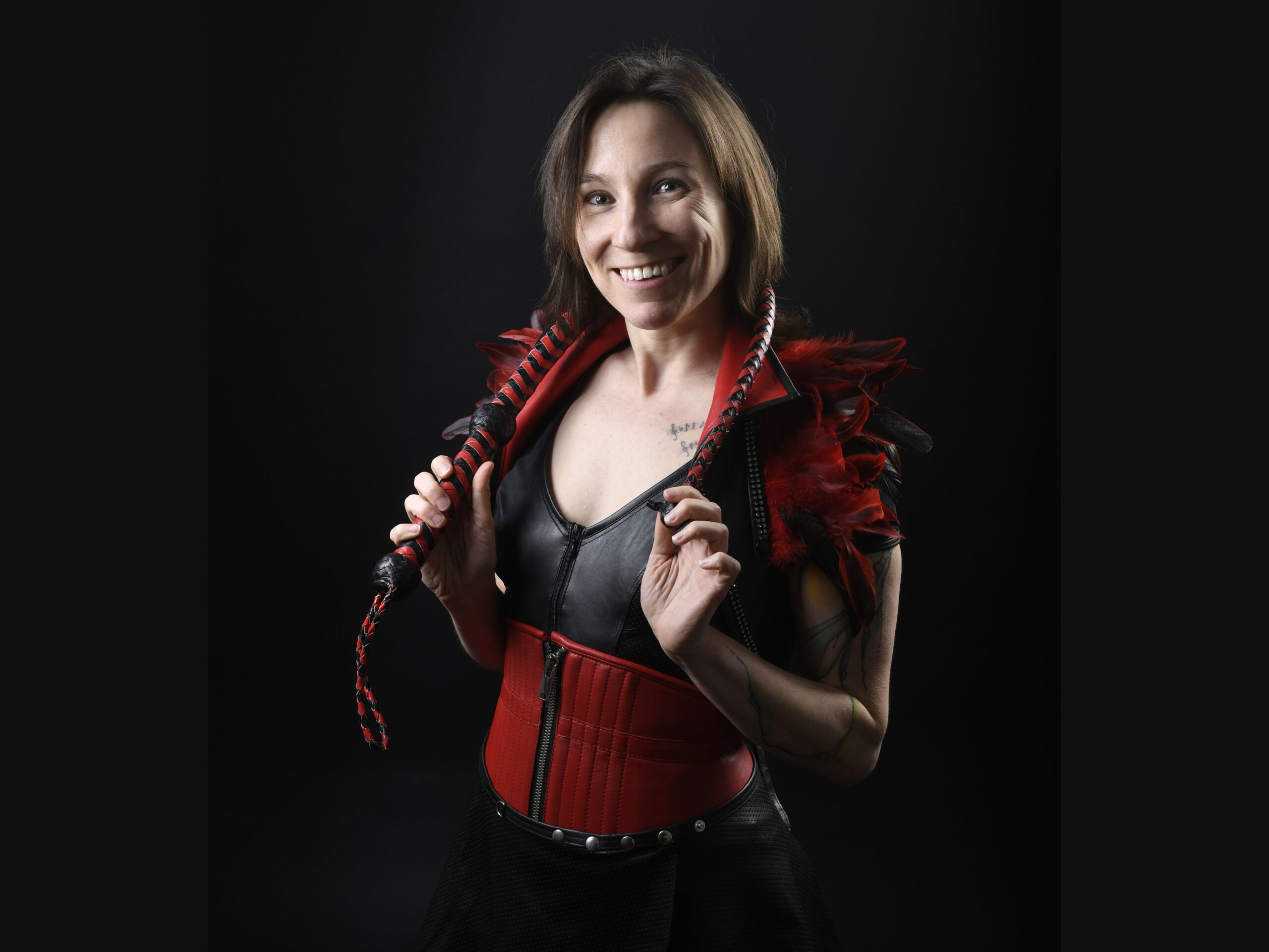 Portrait von Jay lachend mit Peitsche und in Fetisch Outfit für BDSM für Anfänger