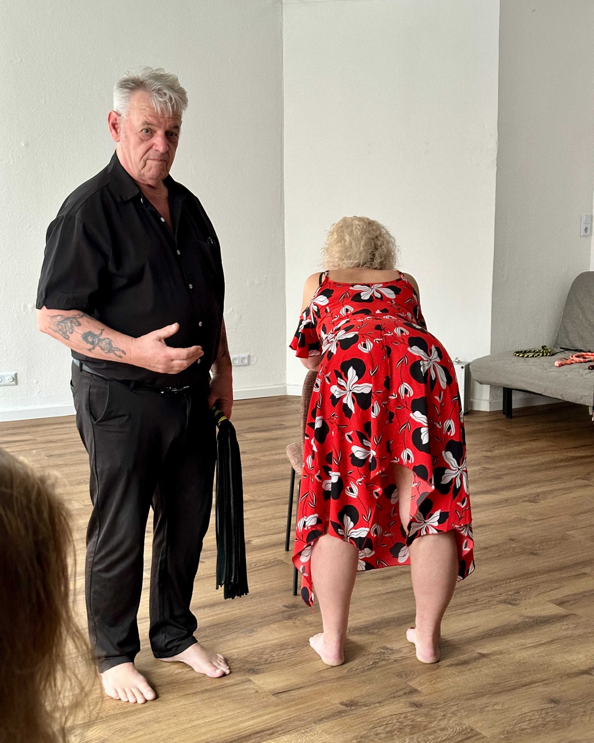 Ron neben seiner Partnerin, die nach vorne gebeugt ist, beim Bullwhip Workshop im Refugium Aschaffenburg