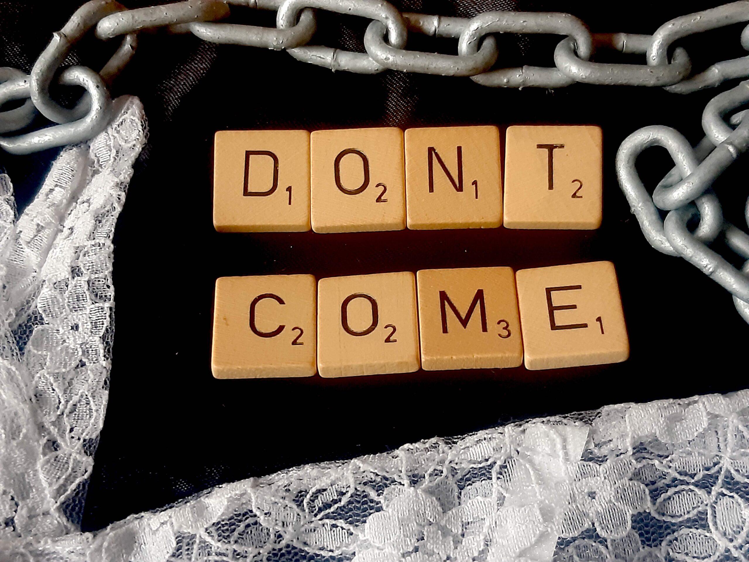 Buchstaben aus Holz umgeben von Rüschen und Ketten "Don't Come" Playparty